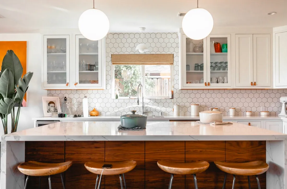Bright modern kitchen remodel with marble waterfall island and hex-tile backsplash