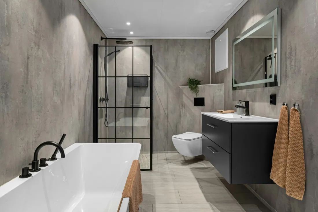 Modern bathroom remodel with freestanding tub, glass shower and concrete-look walls