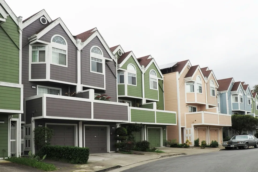 Row of multi-story townhouses with garages, an ADU-style streetscape