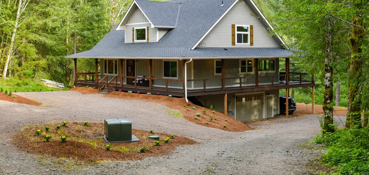 Farmhouse exterior after new siding, trim and a wraparound covered porch