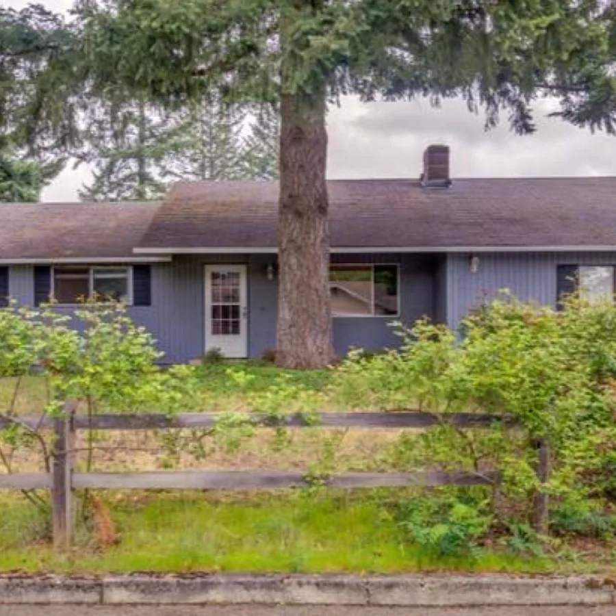 Ranch home before its exterior remodel, with failing siding and paint