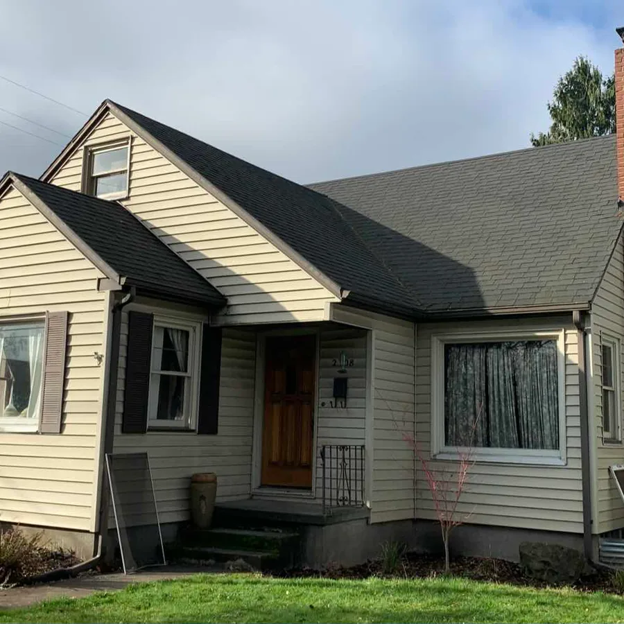 Bungalow before its exterior remodel, with dated siding and shutters