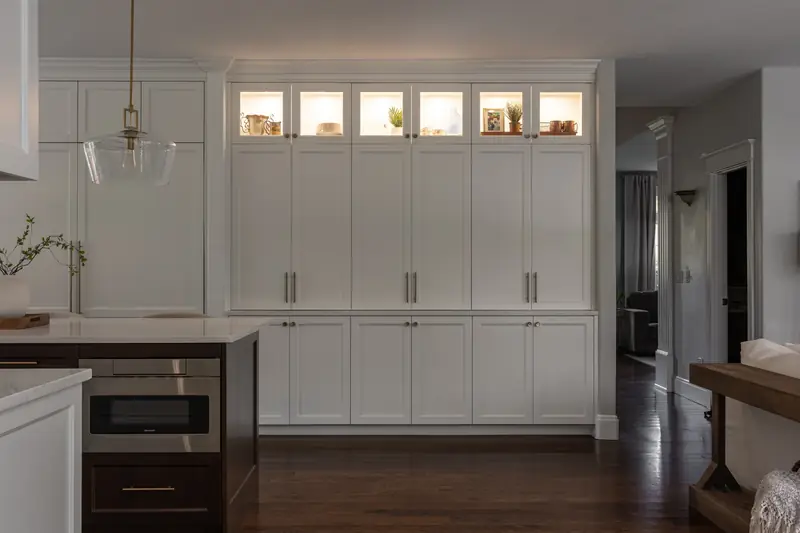 Built-in cabinet wall with its glass-front display cabinets lit from inside