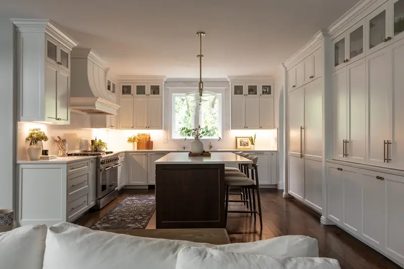 Evening view from the living room with under-cabinet lighting glowing across the backsplash