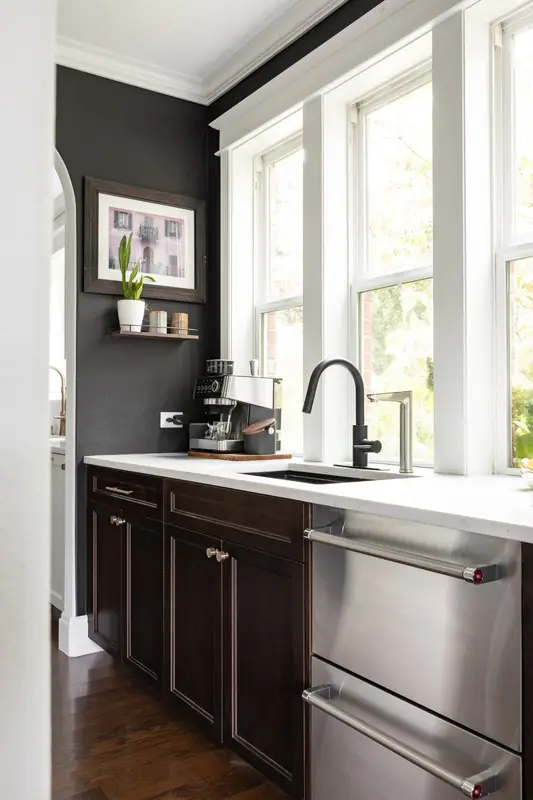 Butler's pantry with charcoal walls, dark cabinetry, a black faucet and stainless drawers