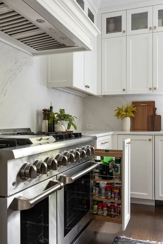 Pull-out spice rack next to a stainless dual-fuel range