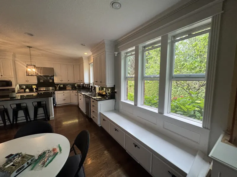 Before the remodel: a long window seat under the triple windows where the kitchen could have used cabinets