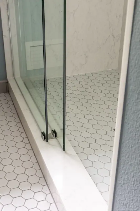 Low-threshold shower entry with sliding glass and hexagon tile floor