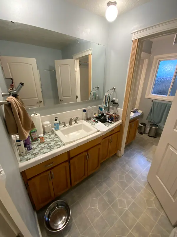Before the remodel: the tile-topped vanity, the partition wall and the second vanity beyond it