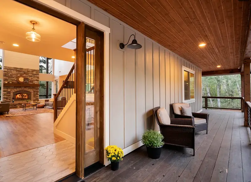 Cedar-ceilinged porch and open front door looking through to the stone fireplace — Battle Ground, WA