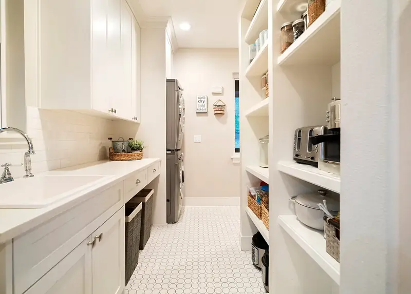 Walk-through pantry and laundry with open shelving and penny-round tile floor — Battle Ground, WA