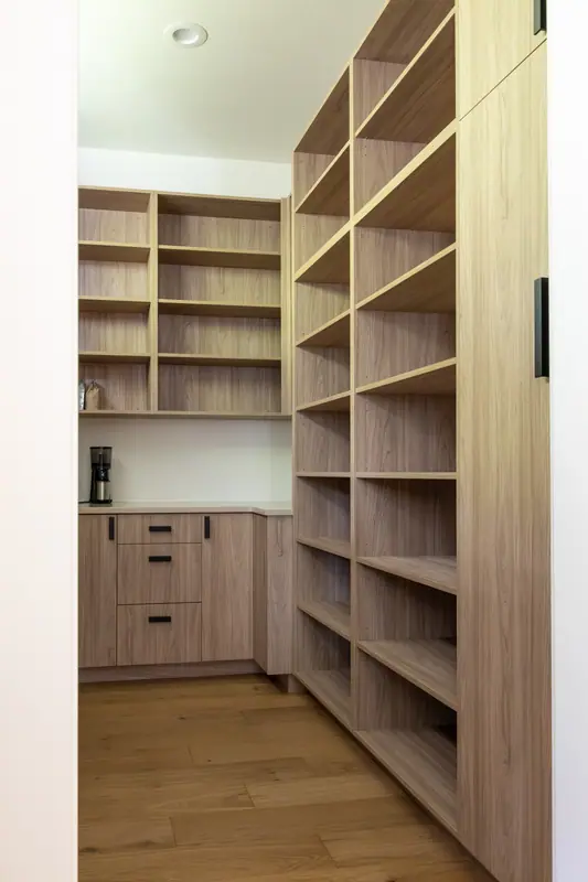 Floor-to-ceiling white oak open shelving in the walk-in pantry, with base cabinets and the coffee-station counter