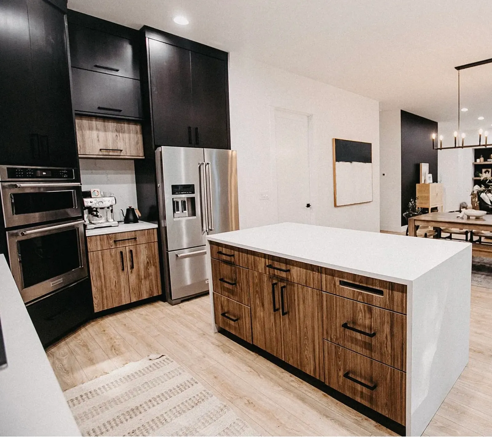 The original island and oven stack before remodeling, looking through to the dining room past a black accent wall