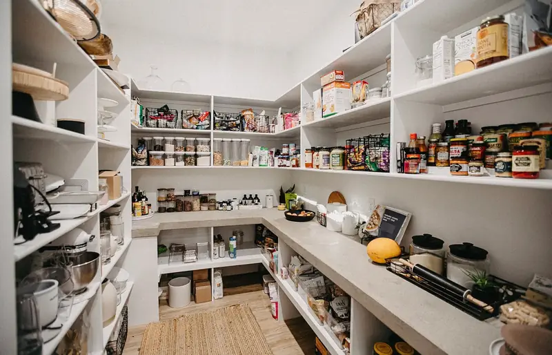 Before the remodel: the original walk-in pantry, fitted out with plain white painted open shelving on three walls over a white counter
