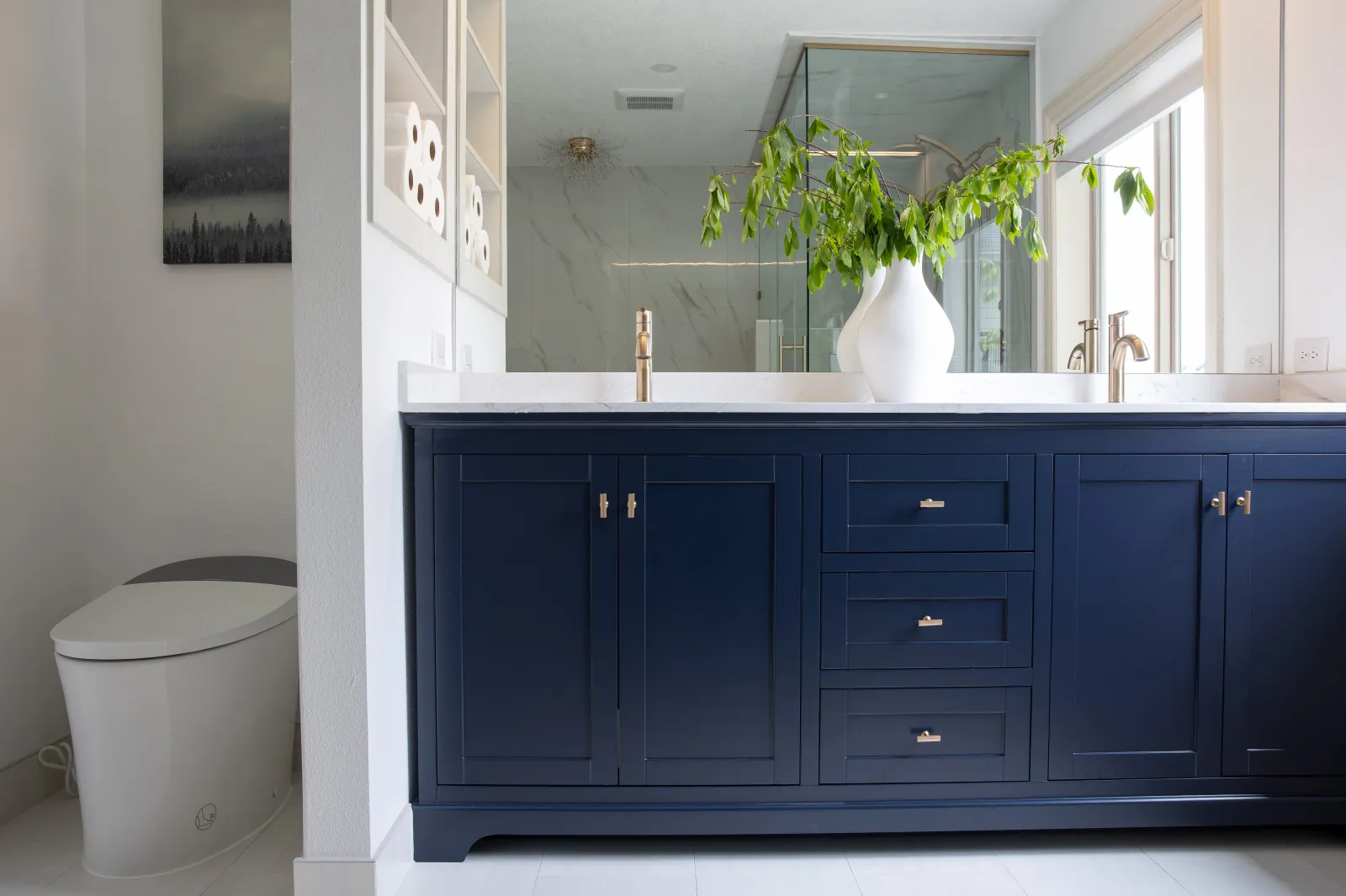 The finished 72-inch navy shaker double vanity with quartz counter, brushed gold faucets and recessed niche storage
