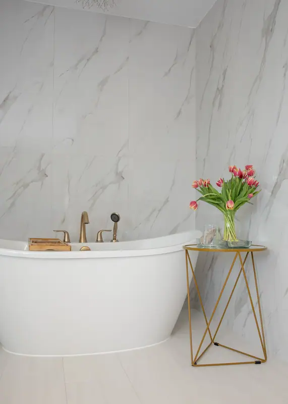 Spa-inspired primary bathroom with heated porcelain floor tile and frameless glass shower