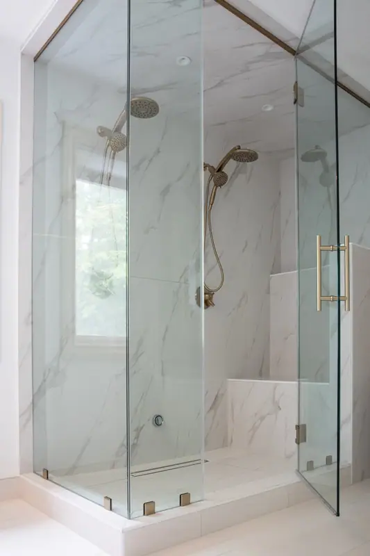 Brushed gold rain head and handshower inside the steam shower enclosure