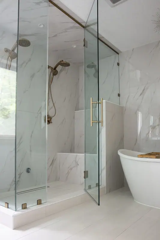 Steam shower enclosure with bench, linear drain, dual shower heads and frameless glass to the ceiling