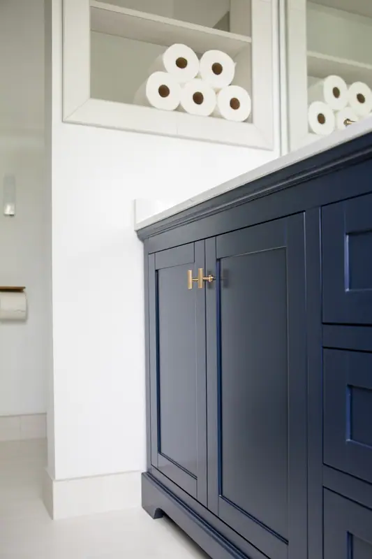 Navy vanity base, brushed gold pulls and open niche storage