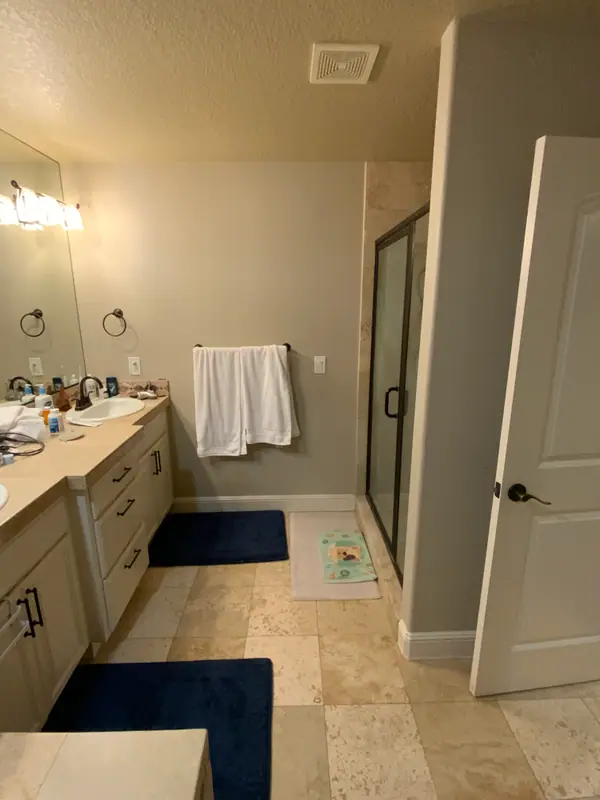 Before the remodel: the walkway pinched between the vanity run and the framed corner shower