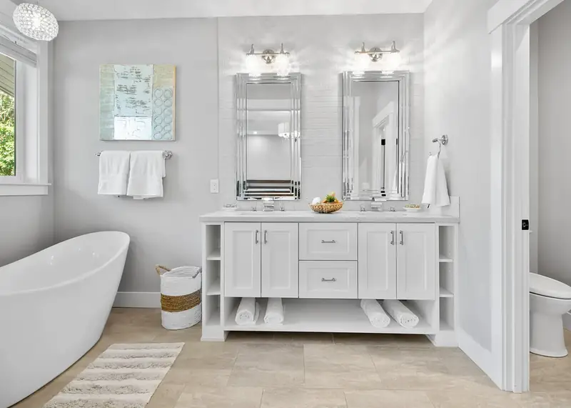 Primary bath with a freestanding soaking tub, white double vanity and tiled feature wall — Vancouver, WA