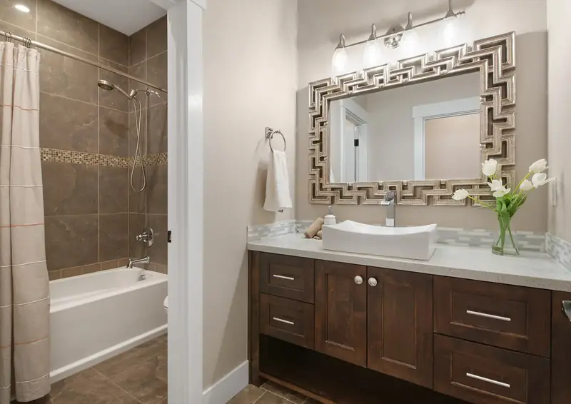 Guest bath with a tiled tub surround, dark shaker vanity and a vessel sink — Vancouver, WA