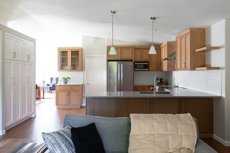 Open-plan Felida kitchen and living room after remodeling, with white oak cabinets and quartz counters