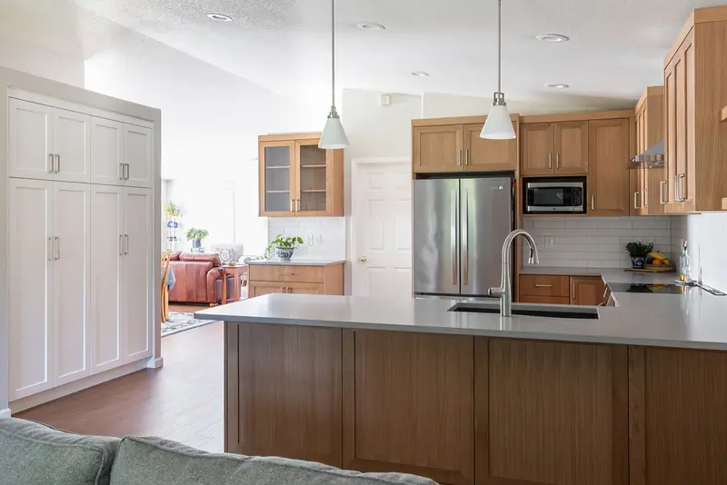 Lengthened quartz peninsula with the white painted pantry cabinet beyond it