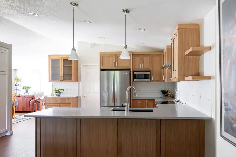 Quartz peninsula, stainless refrigerator and the full-height white pantry in one view