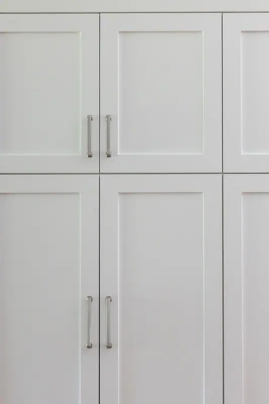 Painted alder pantry doors in a white shaker profile with brushed nickel pulls