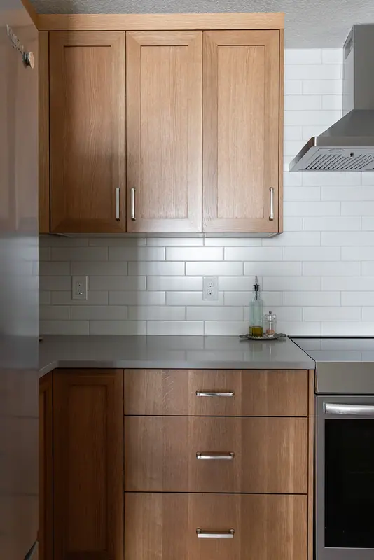 White oak uppers, range hood and a bank of drawers on the cooking wall