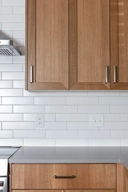 Upper cabinets, subway tile backsplash and a deep pan drawer at the range