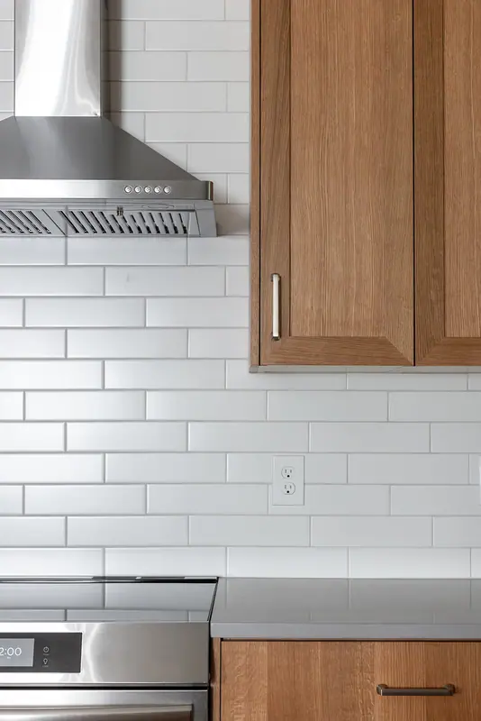 Chimney hood and subway tile above the slide-in range
