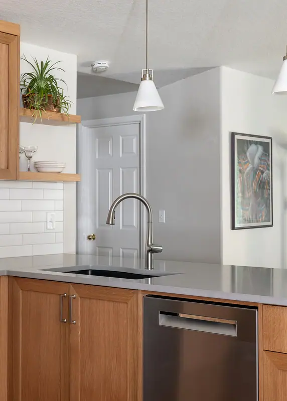 The peninsula from the hallway, with the sink, dishwasher and floating shelves
