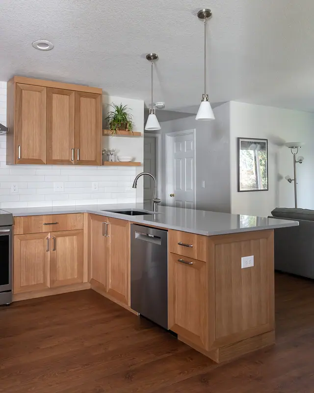 Wide view of the L-shaped run, range, dishwasher and the lengthened peninsula