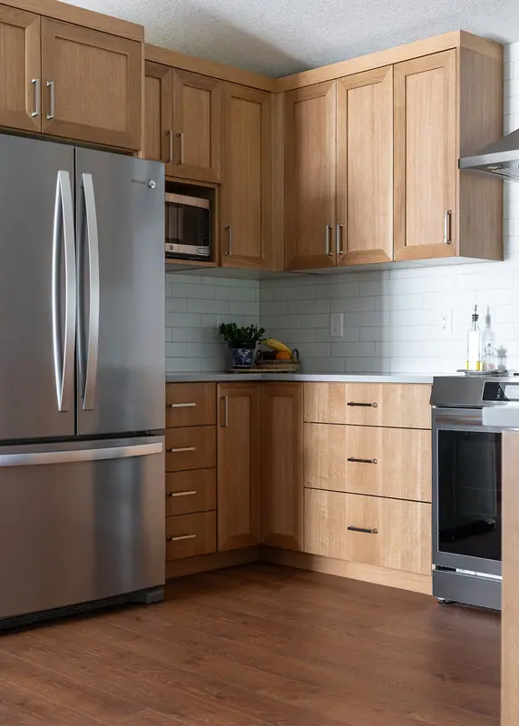 Kitchen corner with refrigerator, microwave cabinet and range over hardwood-look flooring