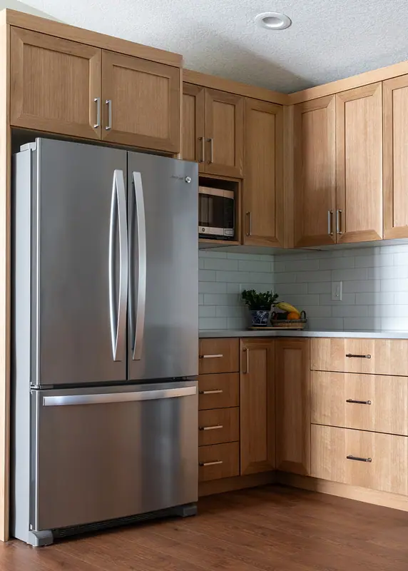Stainless refrigerator with the microwave cabinet above and the corner counter alongside