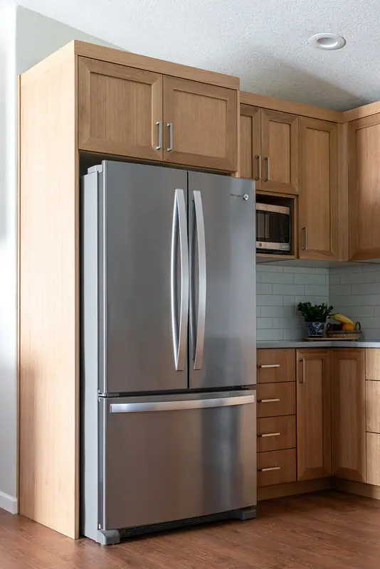 Refrigerator set into a cabinet-depth white oak surround
