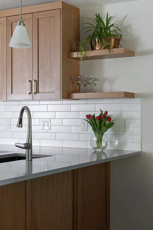 Peninsula sink and faucet with floating shelves and fresh tulips
