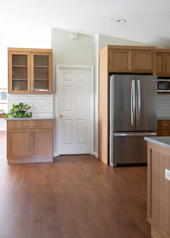 Wide view from the great room showing the pantry, laundry door and refrigerator