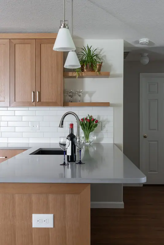 The peninsula with its sink and floating shelves, with the hallway beyond