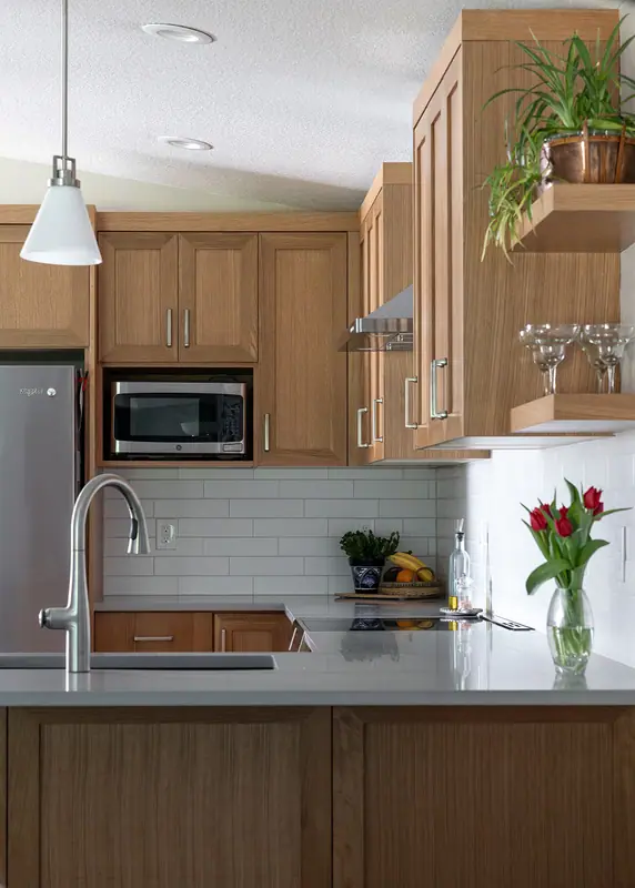 Sink wall, microwave cabinet, floating shelves and pendant in the finished kitchen