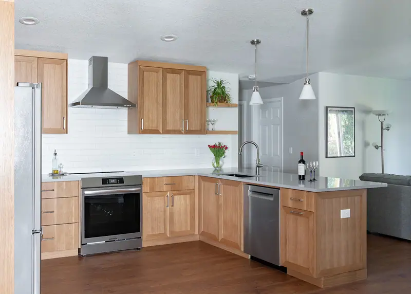 Range hood, range, dishwasher and peninsula seen from the hallway