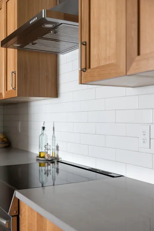 Chimney hood and white subway tile detail above the range
