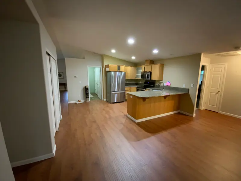 Before the remodel: the kitchen closed off behind its short peninsula, seen from the great room