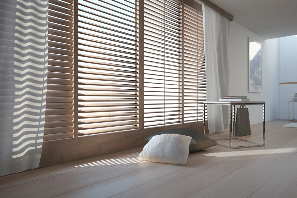 A room with wooden blinds and a white wall.